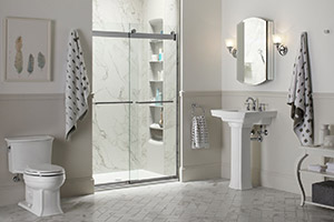 White, modern bathroom with a toilet, sink, vanity mirror, and a walk-in shower